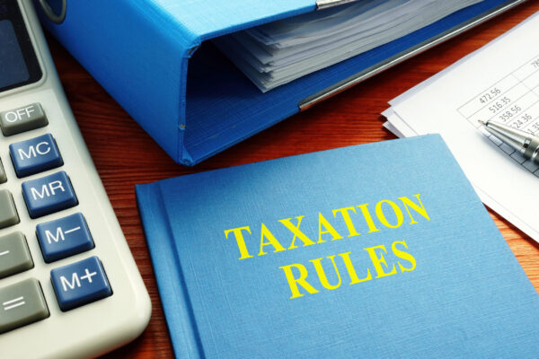 Taxation rules binder, calculator, and financial documents representing 401k rollover tax rules in Utah.